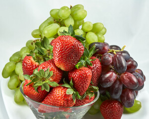 strawberries and grapes clustered on plate
