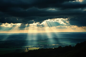 Dramatic Sun Rays Breaking Through Dark Clouds Over Lush Green Landscape Serene Peaceful Nature Scene Breathtaking View Stunning Scenery Picturesque  