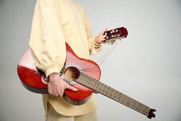 Woman holding broken guitar. Musician holding broken classical guitar neck. Frustrated angry...