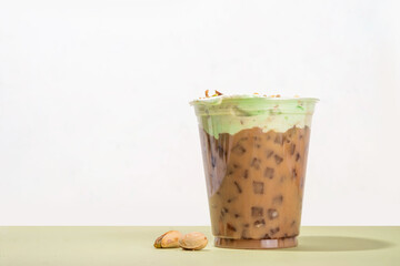 Vegan pistachio milk coffee latte. Iced and hot coffee drinks with plant based whipped pistachio creamer, copy space