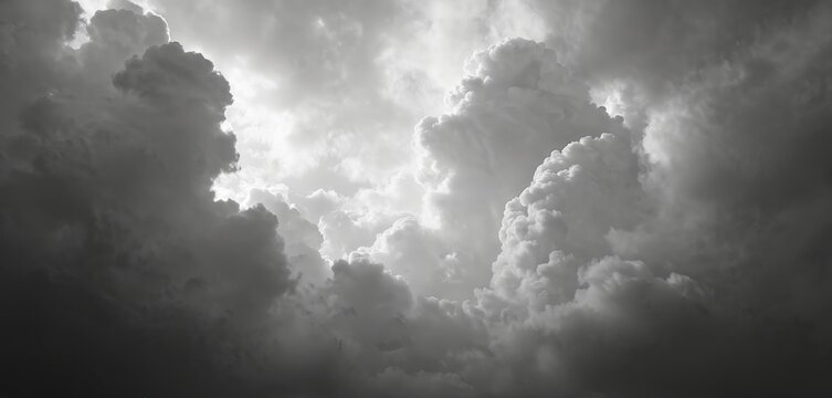 Dramatic black, white photo of cumulonimbus clouds in sky. Moody monochrome weather nature wallpaper with atmospheric stormy overcast cloudscape, sunlight behind. Concept of freedom, relax at summer