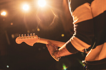Guitarist performing live on stage under warm lights
