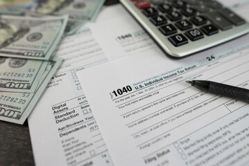 Tax form 1040 on dark wooden background, financial document.