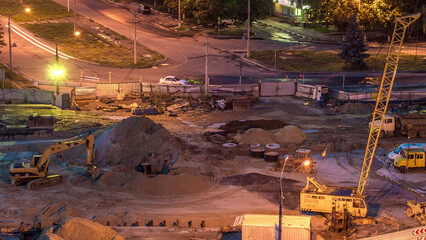 Aerial view of large road construction site with several industrial machines night timelapse. © HyperlapsePro
