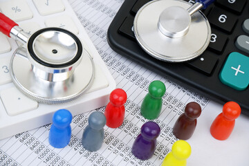 Dfferent stethoscopes on calculators on financial numbers with people figures.