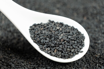 Natural black sesame grains in a spoon macro close-up