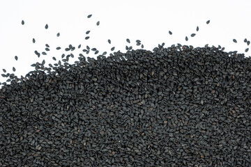Black sesame seeds scattered on a white background place for text