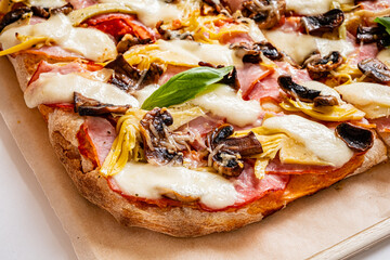 Warm, freshly baked pizza with artichokes, mushrooms, and ham toppings