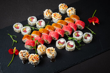 An array of colorful sushi rolls artfully presented with vibrant garnishes on a sleek surface
