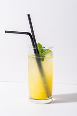 A vibrant citrus beverage awaits enjoyment, adorned with fresh mint leaves and black straws