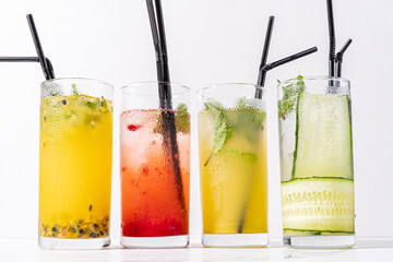 Four glasses filled with refreshing cocktails display an array of vibrant colors and flavors