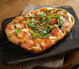 A mouthwatering Italian pizza fresh from the oven, topped with savory pepperoni and peppery arugula