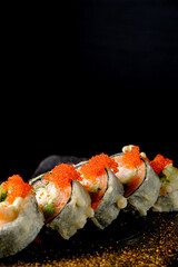 Crispy fried sushi rolls showcase colorful toppings against a dark backdrop