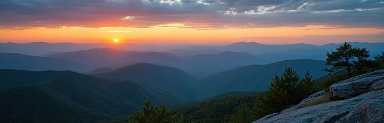 Obraz premium Sunset panorama of Blue Ridge Mountains with colorful sky. Mountain chain silhouettes, pine trees on rocky foreground. Scenic beauty, nature, sunrise, golden hour, horizon view. Outdoors travel