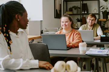 Obraz premium Wide shot of biracial team of young and professional IT specialists chatting with each other during lunch break