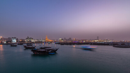 Naklejka premium Evening at Doha Bay day to night timelapse with Traditional Wooden Dhow Fishing Boats.