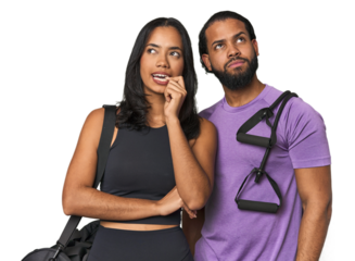 Young Latino couple ready for gym training relaxed thinking about something looking at a copy space.
