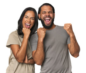 Young Latino couple in studio cheering carefree and excited. Victory concept.
