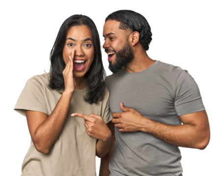 Young Latino couple in studio saying a gossip, pointing to side reporting something.
