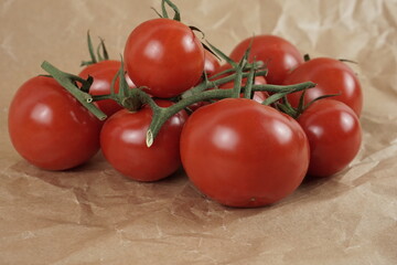 Fresh red tomato on beige craft paper 