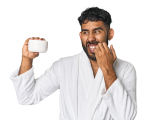 Hispanic male with moisturizer in studio biting fingernails, nervous and very anxious.