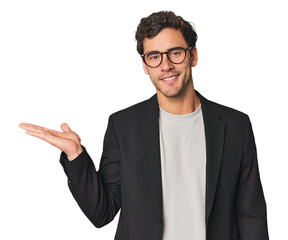 Young Hispanic businessman showing a copy space on a palm and holding another hand on waist.