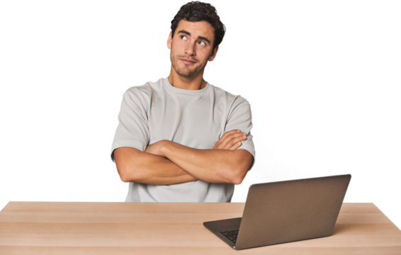 Hispanic young man working on laptop dreaming of achieving goals and purposes