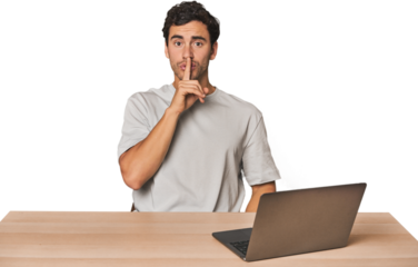 Hispanic young man working on laptop keeping a secret or asking for silence.