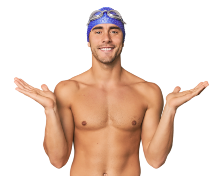 Young Hispanic man with swim gear makes scale with arms, feels happy and confident.