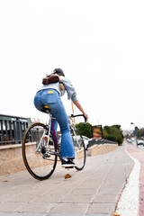 Young woman riding a bicycle in the city as sustainable urban transport