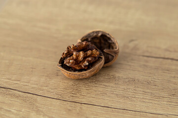 An open walnut in its shell on wooden table. Soft focus