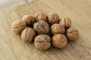 Unpeeled walnuts on wooden table. Natural