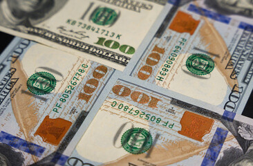 New and old $100 bills joined at the corners