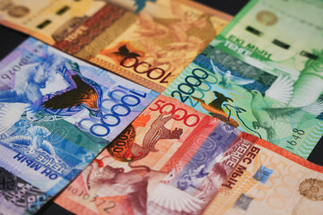 Banknotes of 10,000, 5,000, 2,000 and 1,000 tenge connected at the corners