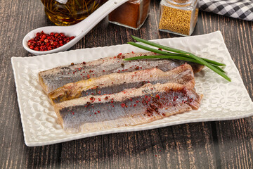 Salted marinated herring fillet with spices