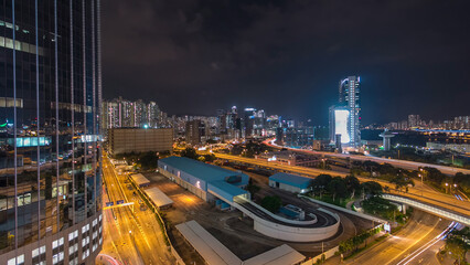 Fototapeta premium Aerial view of busy traffic night in finance urban timelapse hyperlapse with panorama of city buildings, Hong Kong city