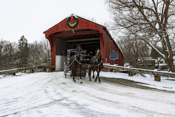 The West Montrose Covered Bridge (also known as the Kissing Bridge) during the winter and a mennonite horse drawn carriage, Waterloo, ON, Canada.