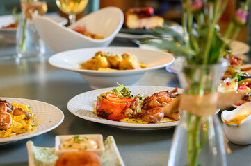 A table with a variety of food and drinks, including a vase of flowers