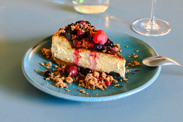 A slice of cheesecake with berries and a cherry on top