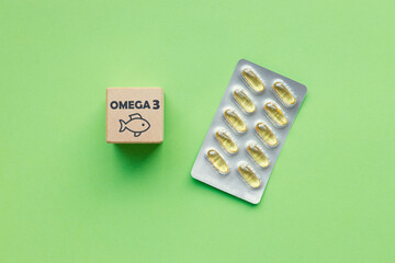 Fish oil capsules and Omega3 icon on green background. Healthcare, wellbeing and supplements concept