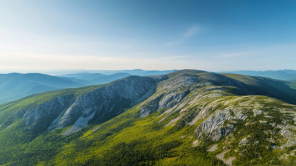 Fototapeta premium Aerial view of mountain range with green valley under blue sky landscape