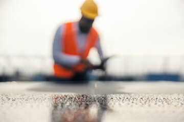Close up of solar panel surface with black engineer in a blurry background.