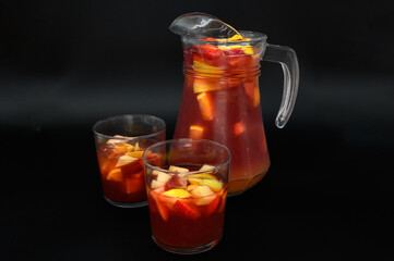 A pitcher of fruit punch is poured into two glasses