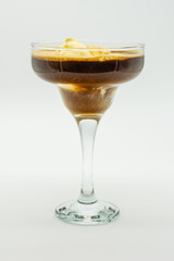 A glass of brown liquid with ice cream in it