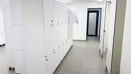 Clean modern locker room interior with white lockers, gym facility or school setting, hygiene concept