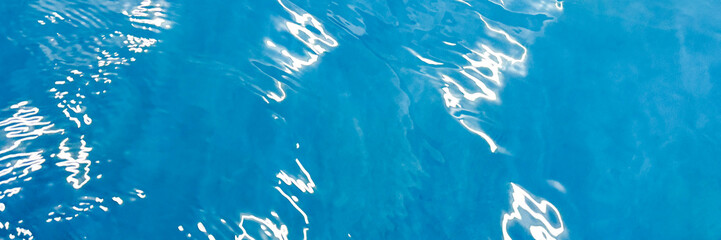 Calm blue water surface reflecting sunlight, tranquil aquatic scenery, suitable for relaxation themes and summer content