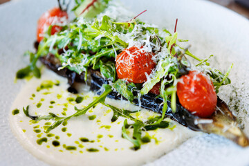 Vegan warm asparagus-broccoli salad with dill aioli, vegan cheese. Delicious healthy vegeterian food served for lunch on a table in modern gourmet cuisine restaurant