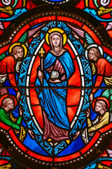 Stained glass (19th century) of Virgin Mary with angels in the heaven.