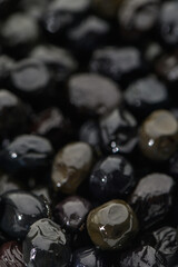 Varied textures and hues in a close-up of glistening black stones reflecting subtle light