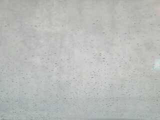 A close-up view of raindrops on a glass surface, creating a soothing, abstract texture. Ideal for backgrounds or themes of weather, tranquility, and clarity.